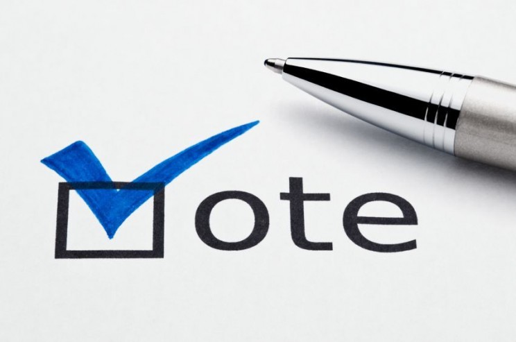Blue checkmark on vote checkbox, pen lying on ballot paper