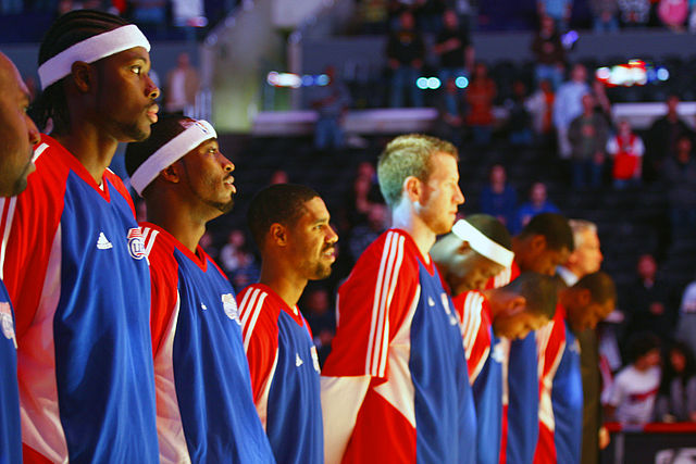 Los Angeles Clippers players stand up for the national anthem before the December 31, 2007 game against the Minnesota Timberwolves at Staples Center. Photo by Paul de los Reyes. CC BY 2.0 via Wikimedia Commons.