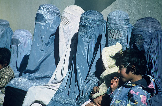 A Group of Women Wearing Burkas. Afghanistan women wait outside a USAID-supported health care clinic. Photo by Nitin Madhav (USAID). Public domain via Wikimedia Commons. 