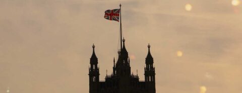 Union Jack flag flying atop a turret against a dusky sky to illustrate the blog post "United kingdoms and European Unions: using global history to better understand the UK" by Alvin Jackson on the OUP blog