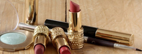 A group of lipsticks sitting on top of a wooden table.