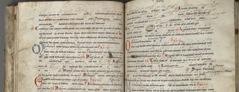 Open ancient manuscript with Latin text and red annotations.