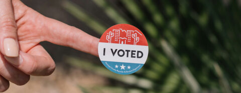 Finger with ‘I Voted’ sticker, implying participation in an election.