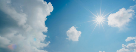 Image of blue sky with white clouds and sun shining