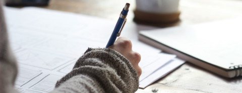 Close up of a woman's hand holding a pen about to write