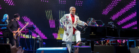 Cropped image of Elton John in silver jacket performing at a concert at Twickenham Stoop in 2017