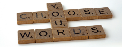 Scrabble tiles spelling "Choose Your Words" on a white background.